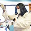 A Black female scientist works in a lab setting