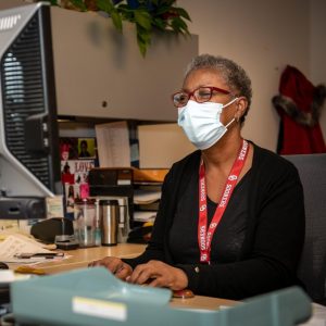 Woman wearing mask types at a desk