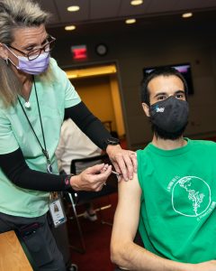 Man receives flu vaccine from nurse.