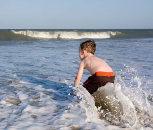 Boy playing in ocean surf