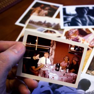 Hand sorting through vintage photographs of family