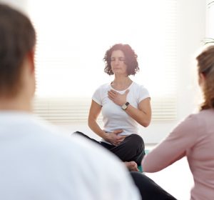 Instructor with group of people in yoga class exercising
